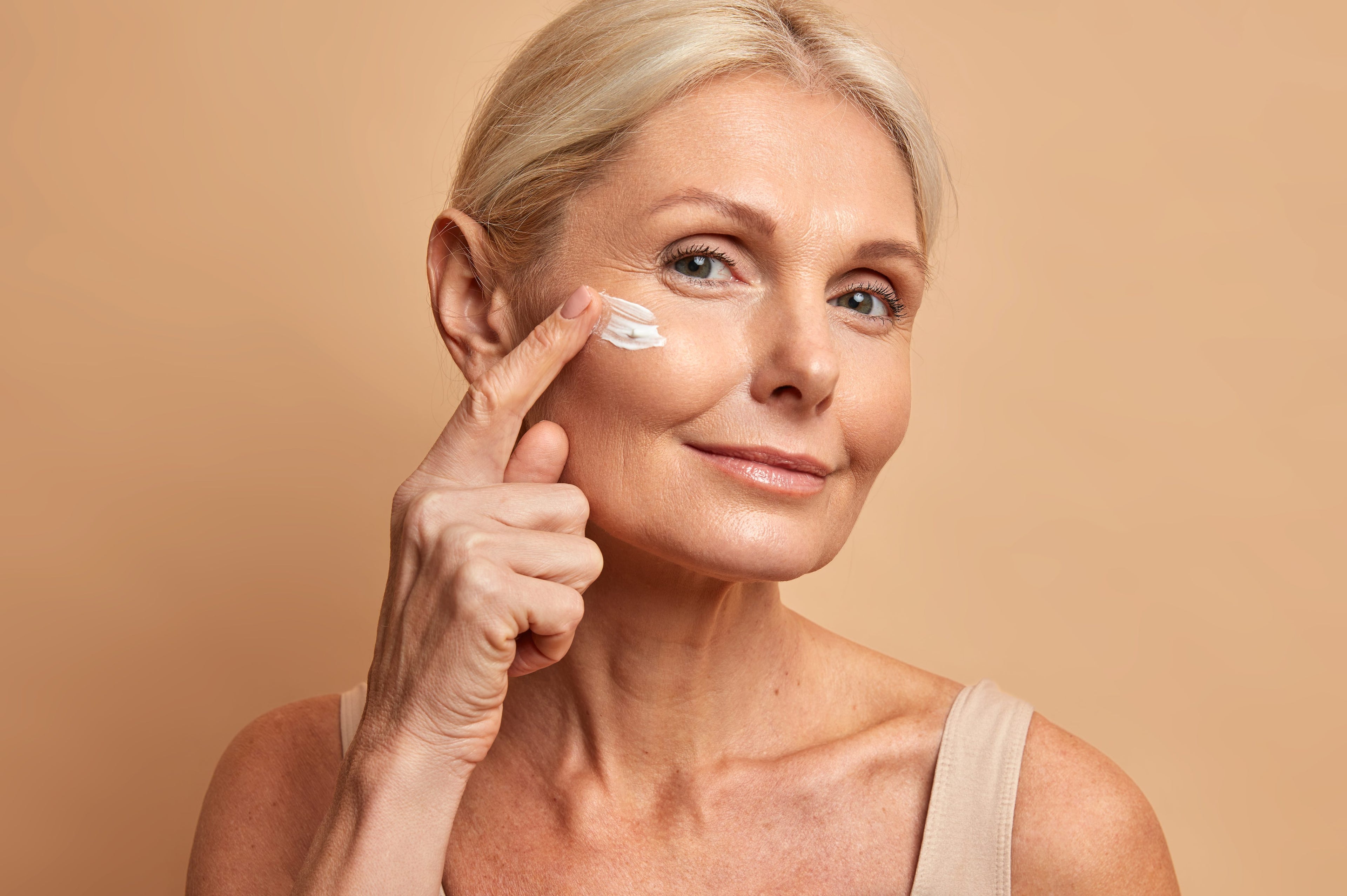 Middle aged women applying Perrin Naturals creams to face